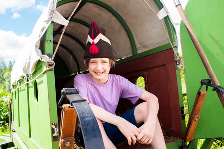 boy in a 19th century French cart or carriage, child on a historical excursion.