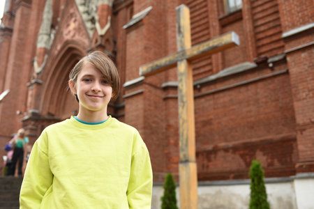 portrait of an 11 year old happy boy in front of a Catholic churchの写真素材