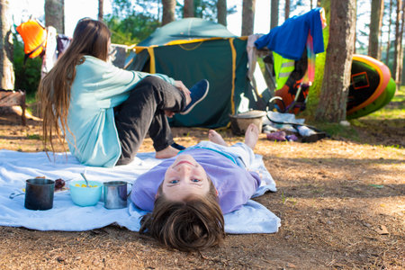teenagers, brother and sister in front of tent in campground in forest during summer holidays.の写真素材