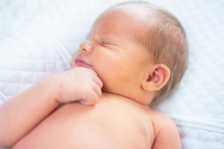 Newborn baby sleeping on a white bed, shallow depth of fieldの写真素材