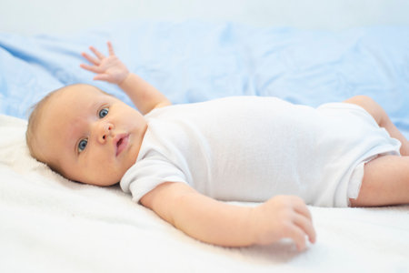 baby boy lying on white bed. Baby is 1 month old. Happy baby morning.