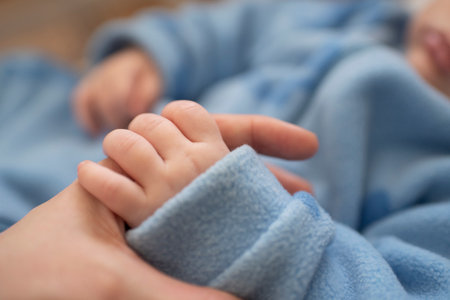Close up of newborn baby's hand holding mother's hand. Focus on handの写真素材