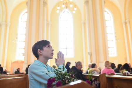Willow branches, carnations, palm leaf on wooden benches in the church.の写真素材
