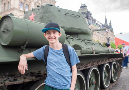 A 12-year-old boy stands next to a Soviet T-34 tank at the "80 Years of Victory" exhibition in Moscow on Red Square.の写真素材