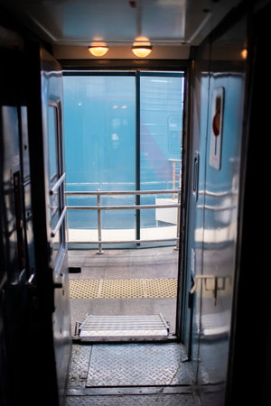 open train doors, view from the dark vestibule of the carriage onto the morning platformの写真素材