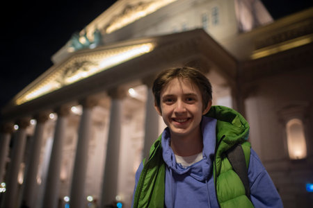 Teenage boy on an evening excursion around Moscow. Portrait of a child against the backdrop of the Bolshoi Theatre.の写真素材