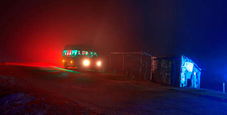 Silhouette of a camper van in the mountains at night.の写真素材
