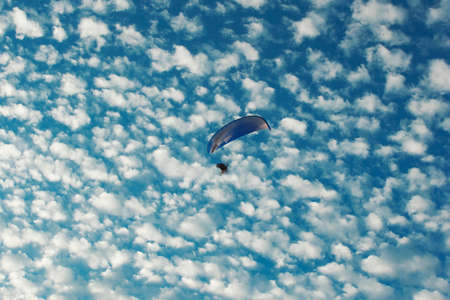 Paraglider flying in the blue sky with white clouds. Paraglider flying in the blue sky.の写真素材