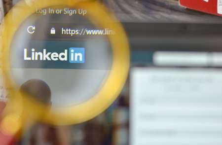 New York, USA, 2020. Linkedin website signup page through a magnifying lens. Out of focus laptop screen is in the background. Concept social networkのeditorial素材