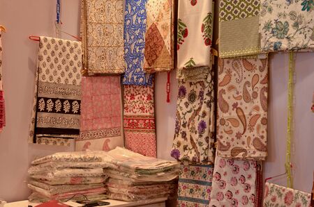 Fancy sarees / unstitched suits hanging and folded on display in a Swadeshi khadi handloom exhibition at Dilli Haat, New Delhi, India International Trade Fair (IITF)の写真素材