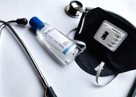 New York, USA, 2020. 3M Grey N95 face mask, sanitizer and stethoscope on a white background denoting doctor's Covid-19 safety kit to reduce the rate of spread of infectionsのeditorial素材