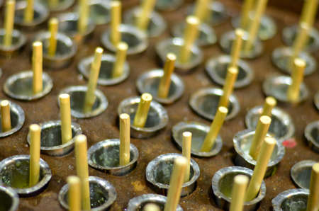 Kulfi sticks protruding out of their metal cases / casting used for freezing them in summers in a roadside shop in Dilli Haat, Delhi, Indiaの写真素材