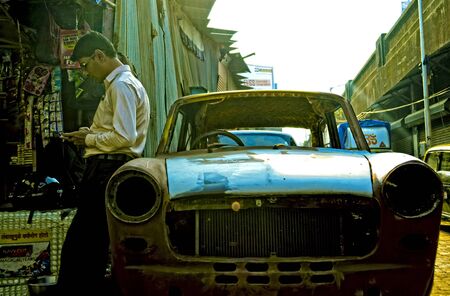 A person standing near broken vintage car in mumbaiの写真素材