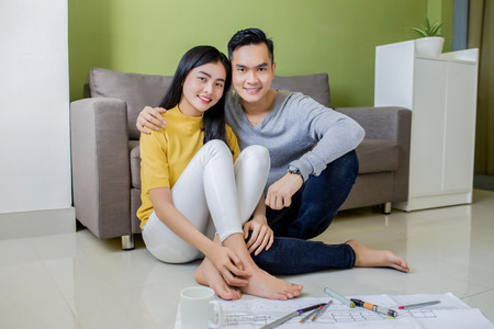 Happy asian couple planning their new apartmentの写真素材