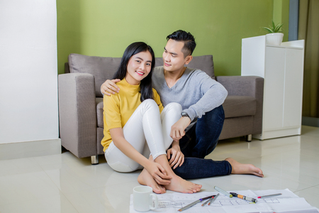 Happy asian couple planning their new apartmentの写真素材