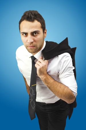 Portrait of a serious good looking businessman holding coat on shoulder.Radial blue gradient as background.Black tie and white shirt.の写真素材