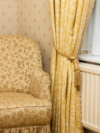 View of brown vintage armchair near retro curtain の写真素材