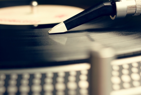 Low angle view of old fashioned turntable playing a track from black vinyl Color cross processed の写真素材