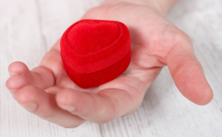 Closeup of red jewelry box placed on palm の写真素材