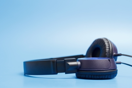 Close-up of quality plastic headphones placed on blue background.の写真素材