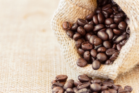 Low angle view of roasted coffee beans in jute bag with copyspace on the leftの写真素材