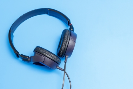 Close-up of quality plastic headphones placed on blue background.の写真素材