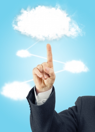 Male hand wearing suit pointing to white cloud in the blue sky. Connection concept.の写真素材