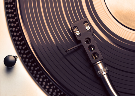 Top view of old fashioned turntable playing a track from black vinyl