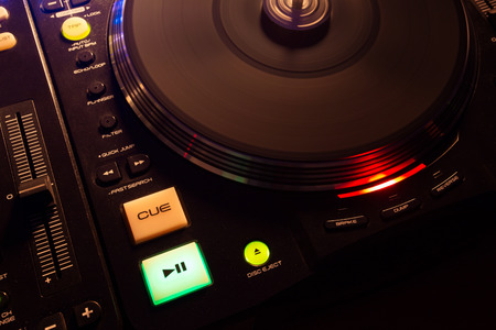 Spinning modern turntable playing music from black vinyl.