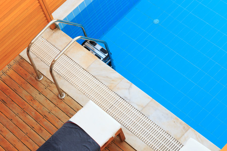 Private pool with clean water and sunbed on wooden elegant floor. Space for text on the right.の写真素材