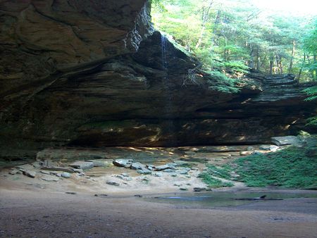 View of rocky overhang with small waterfallの写真素材