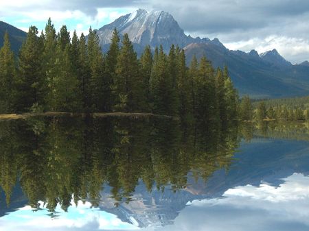 high snowcapped mountain with reflective lake in the foregroundの写真素材