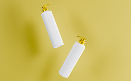 White lotion bottle with gold cap and gold backgroundの写真素材