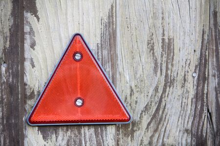 reflective red triangle warning sign on wooden backgroundの写真素材