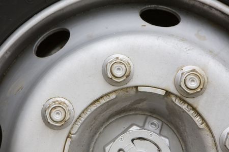 Close up image of a HGV wheel showing nuts that hold the wheel in placeの写真素材