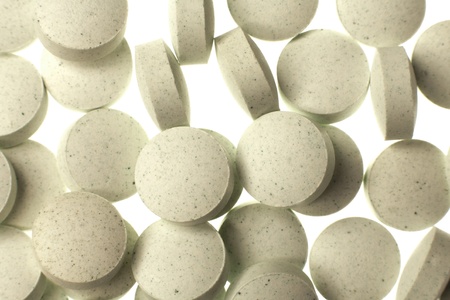 looking down at pills and vitamins on white backgroundの写真素材