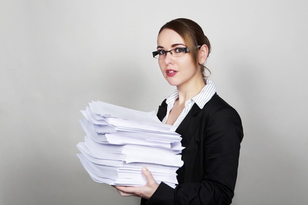 business woman holding lots of paper work to doの写真素材