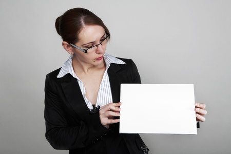 woman in business suit looking at a white cardの写真素材
