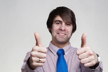 business looking man in a shirt and tie doing hand gestures, thumbs upの写真素材