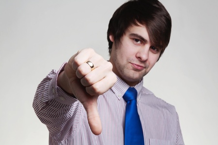 business looking man in a shirt and tie doing hand gestures, thumbs dowmの写真素材