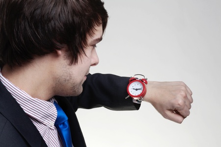 young business man looking at a large watch on his wristの写真素材