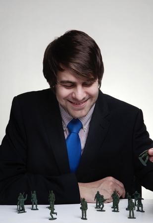 business man playing with toy soldiersの写真素材