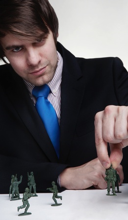 business man playing with toy soldiersの写真素材
