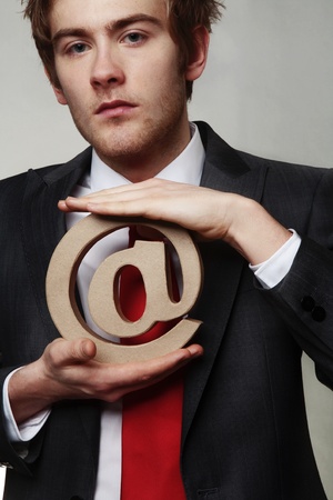 businessman holding the at sign for emailの写真素材