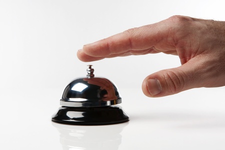 someone's hand pressing a service bell what could they wantの写真素材