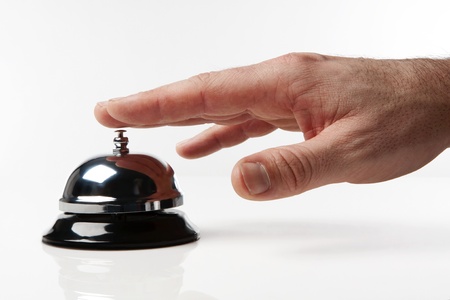 someone's hand pressing a service bell what could they wantの写真素材