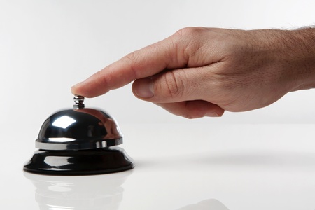 someone's hand pressing a service bell what could they wantの写真素材