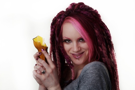 woman with dread lock hair holding a broken beer bottle what is she going to do with itの写真素材