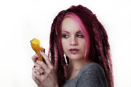 woman with dread lock hair holding a broken beer bottle what is she going to do with itの写真素材