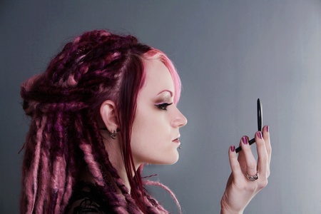 woman with dread lock hair doing her make upの写真素材